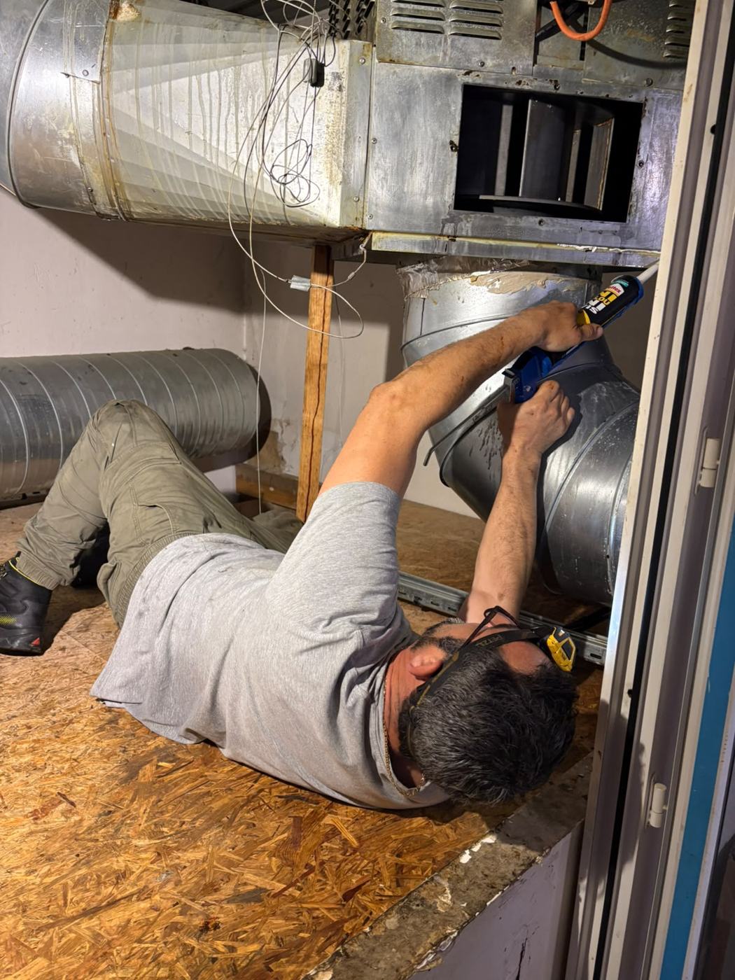 Technicien intervenant sur une gaine d'extraction circulaire