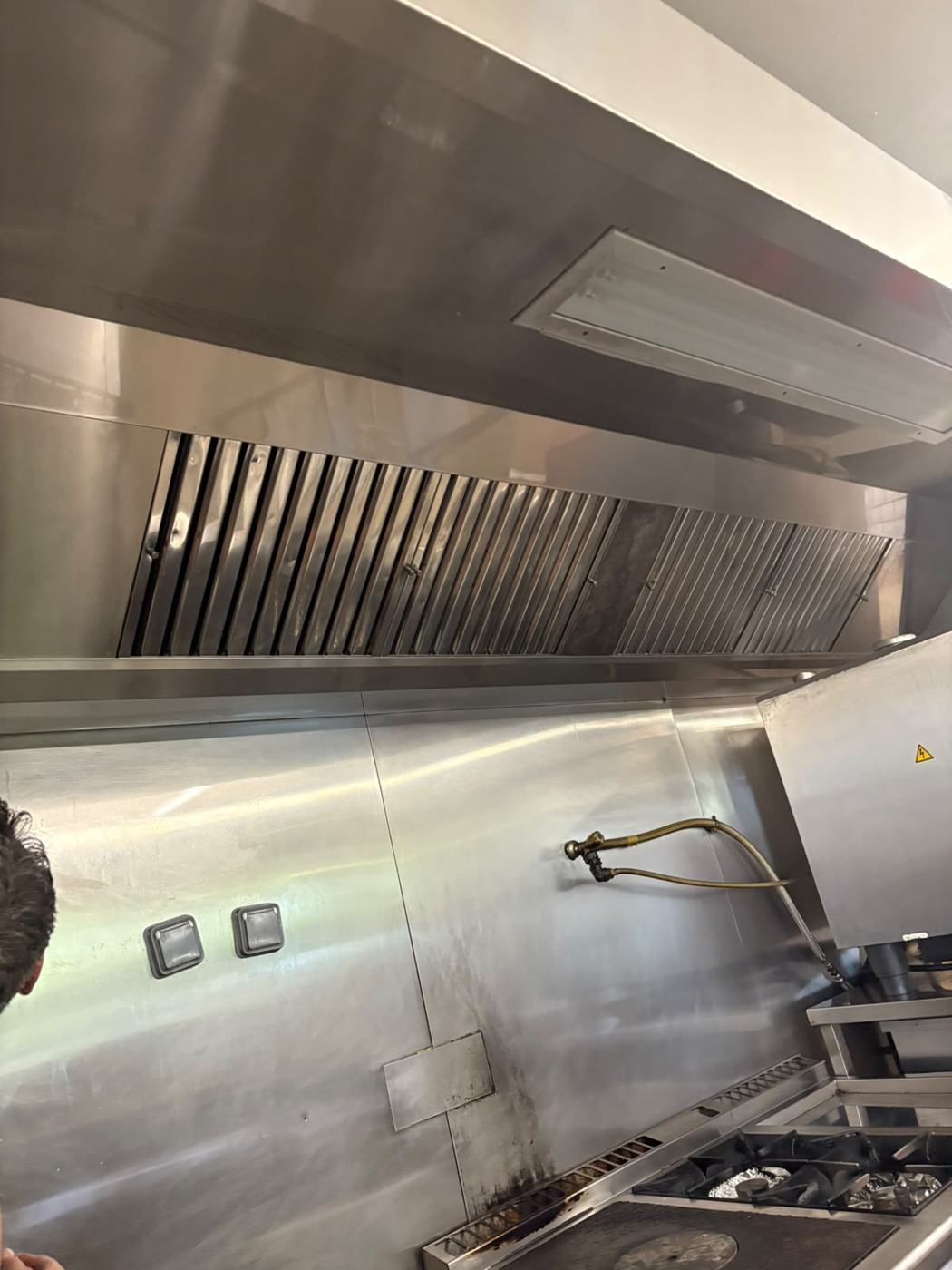 Hotte inox avec filtres à chicanes et éclairage, prête à fonctionner