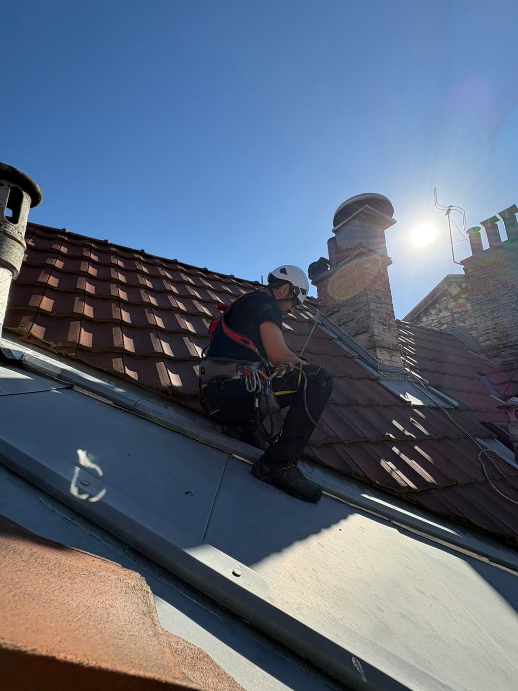 Technicien encordé sur un toit pour accéder à une tourelle